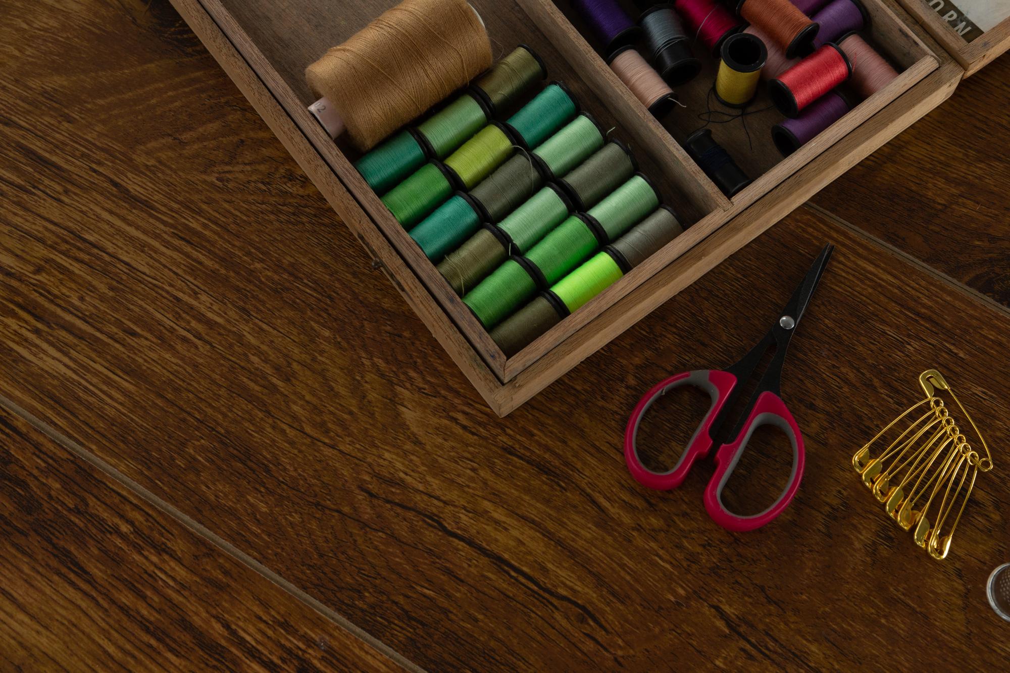 Needles and thread on a wooden table